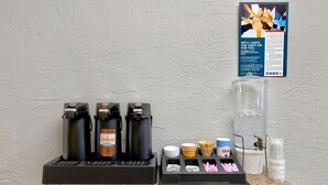 A coffee station with multiple coffee dispensers, sugar, and napkins.