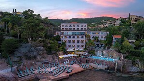 A resort with a pool area, multiple balconies, and a view of the surrounding landscape. - Tiara Miramar Beach Resort (Theoule-sur-Mer)