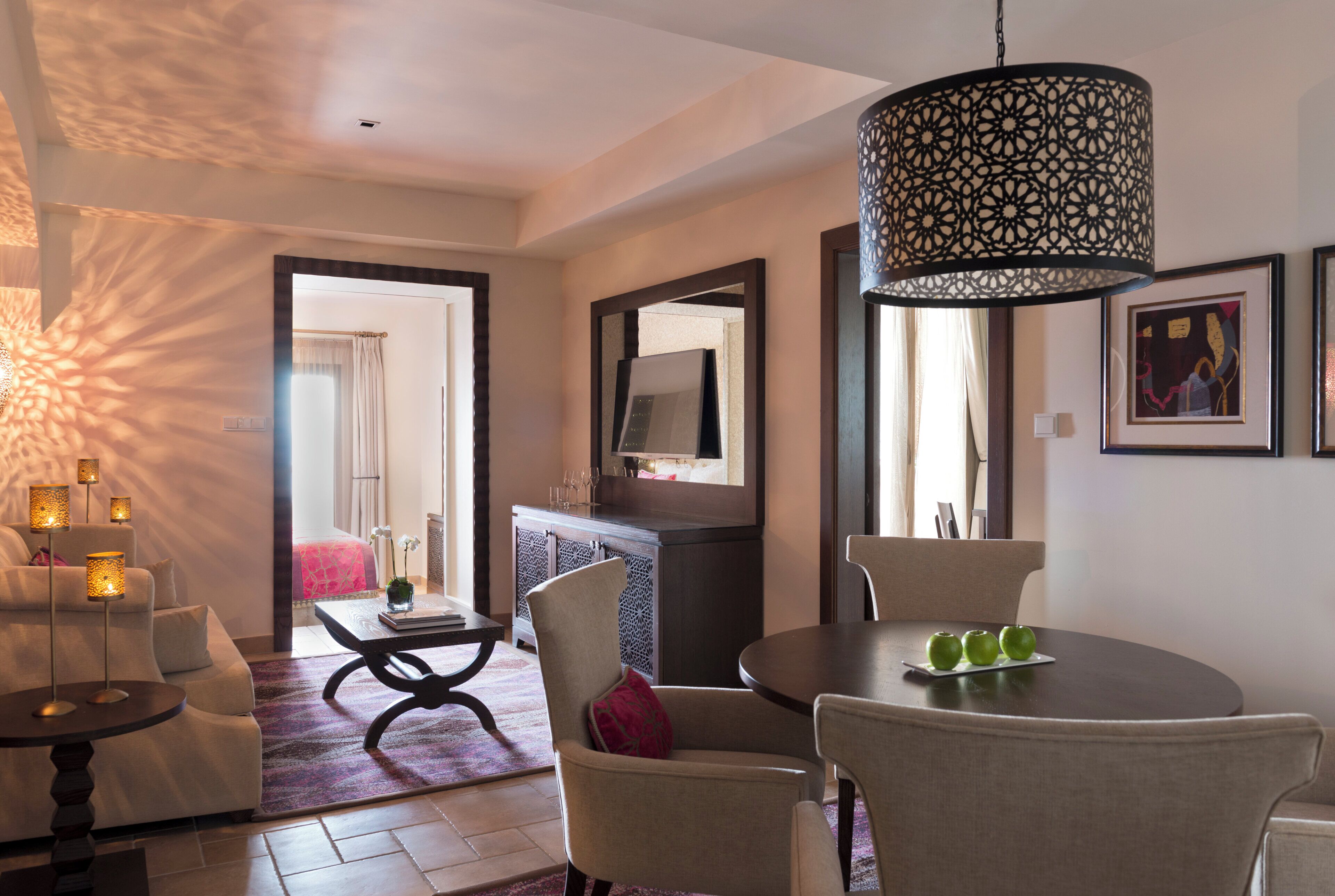 A modern living room with a sofa, a dining table with chairs, a coffee table, a TV, and a decorative lamp.