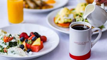 A breakfast setting with plates of food, a glass of orange juice, and a coffee mug.