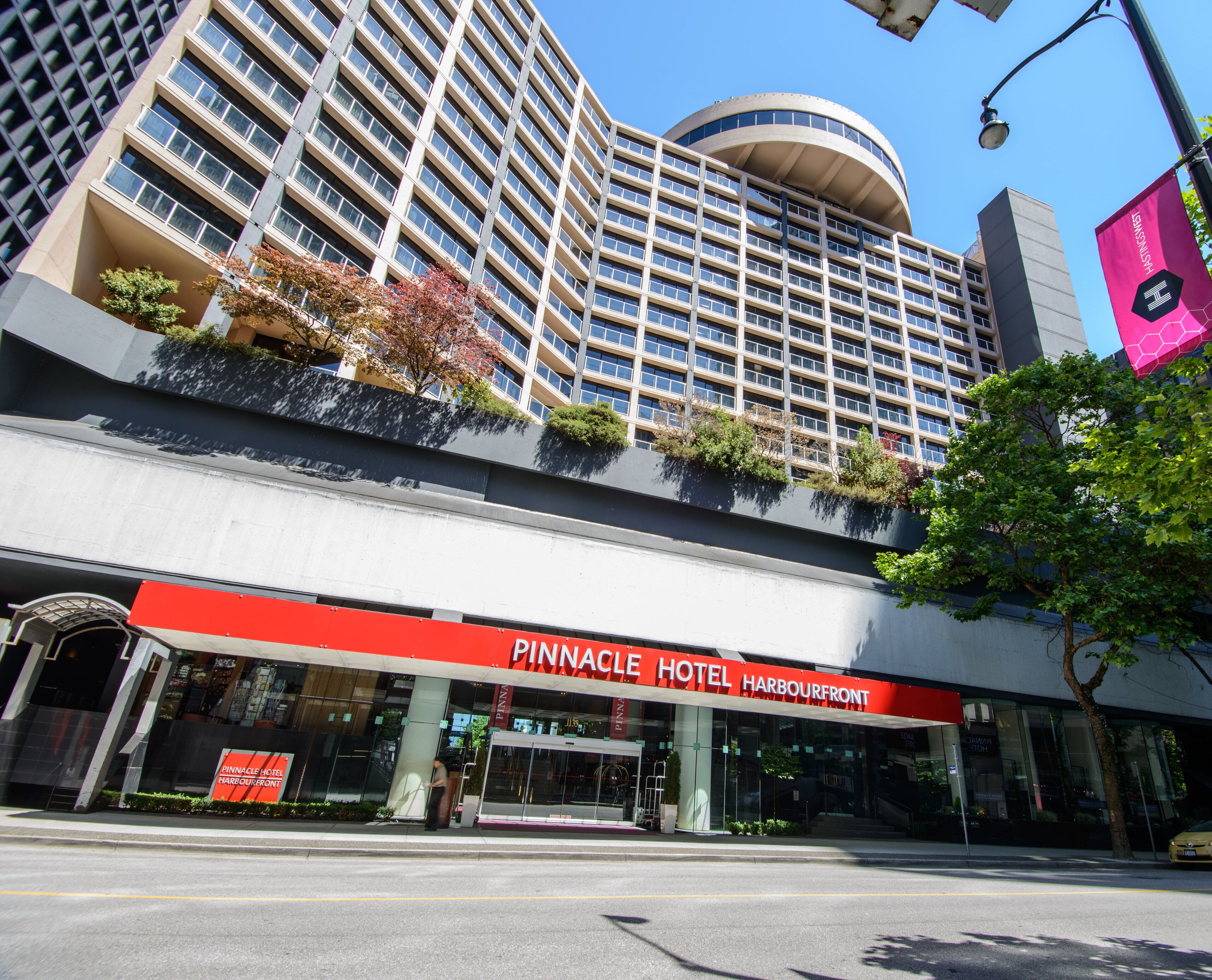 The Pinnacle Hotel Harbourfront with a modern facade, large windows, and a prominent red sign.