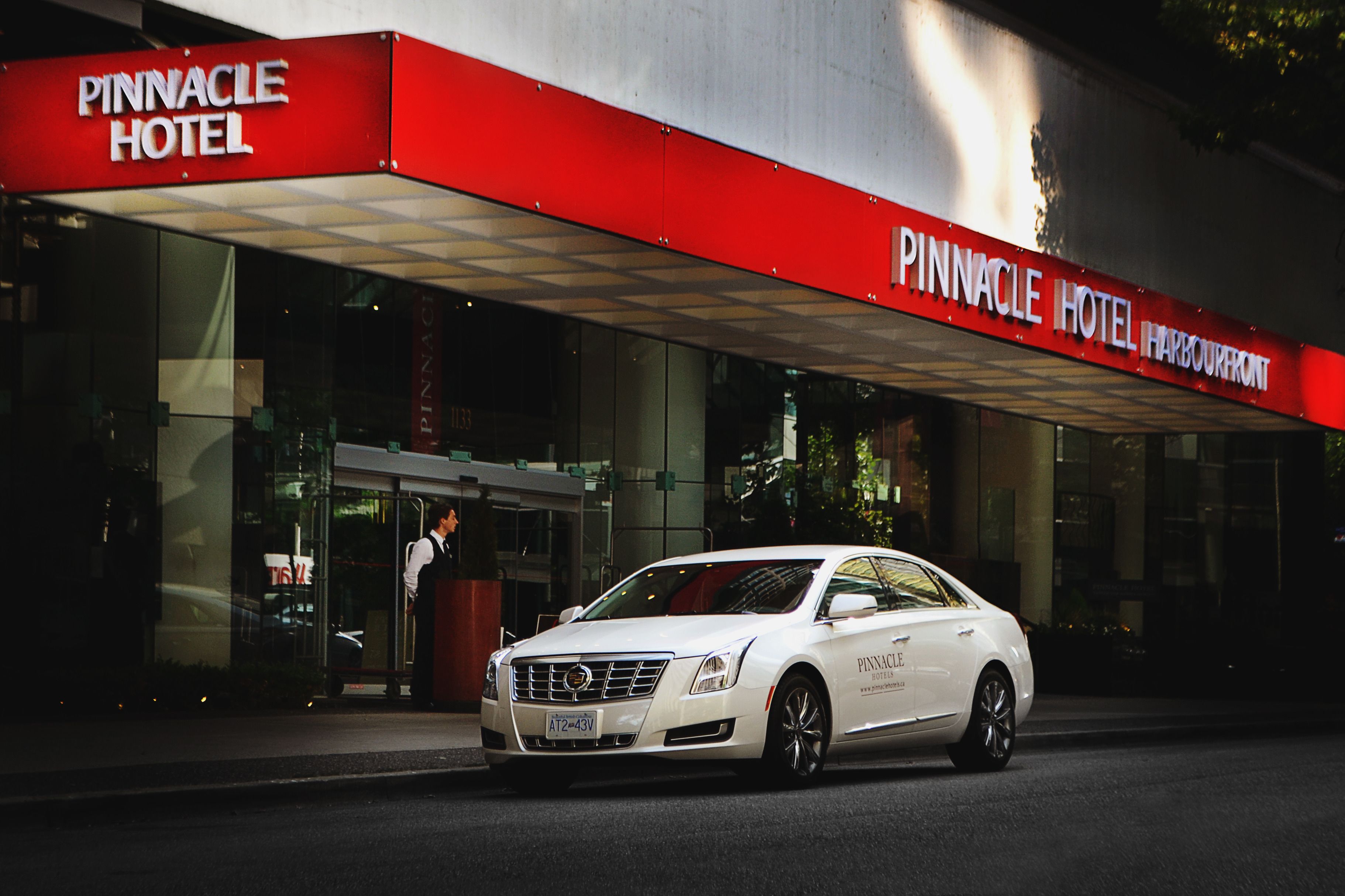 Une voiture blanche était garée devant l’hôtel Pinnacle.