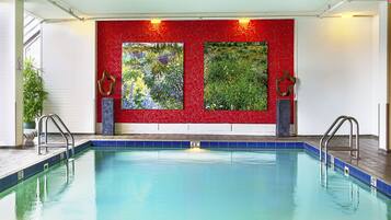 Swimmers can enjoy a safe and refreshing experience in this pool, surrounded by vibrant artwork and a potted plant.