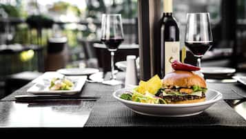 Una mesa de comedor con un plato de comida, una botella de vino y dos copas de vino.