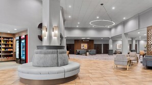 A spacious lobby with a central seating area, a reception desk, and a large wall-mounted artwork. - Holiday Inn Dubuque/Galena by IHG (Dubuque)