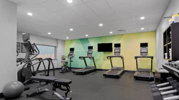 A gym with treadmills, elliptical machines, and free weights.