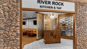 A restaurant entrance with a sign reading "RIVER ROCK KITCHEN & TAP." - Holiday Inn Dubuque/Galena by IHG (Dubuque)