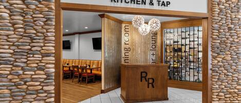 Entrada a un restaurante con un letrero que dice "RIVER ROCK KITCHEN & TAP".