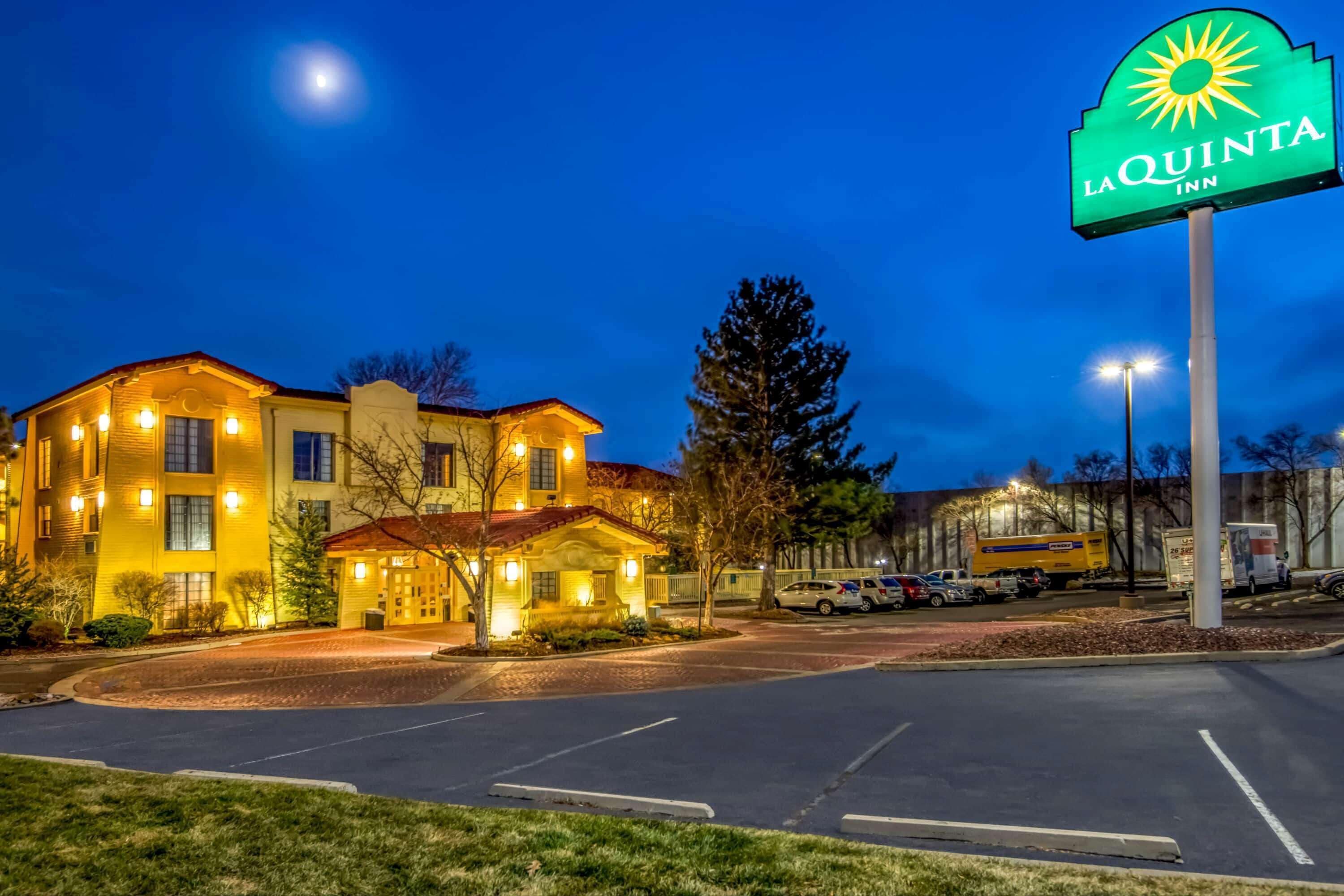 A hotel with a large sign reading "La Quinta Inn" and a well-lit building with multiple windows.