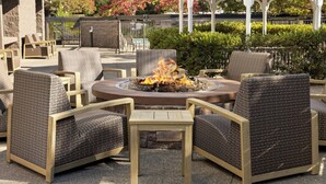 An outdoor seating area with wicker chairs and a central fire pit. - Courtyard by Marriott Santa Rosa (Santa Rosa)