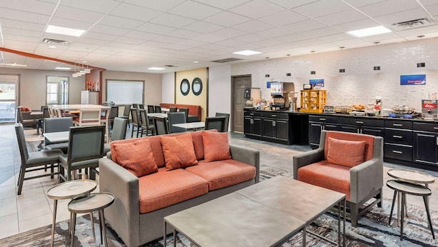 A modern hotel lobby with a seating area, a kitchenette, and a dining area. - Best Western Carlisle (Carlisle)