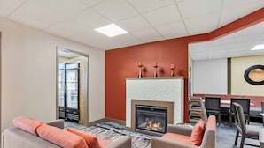 A hotel lobby with a fireplace, seating area, and a dining space. - Best Western Carlisle (Carlisle)