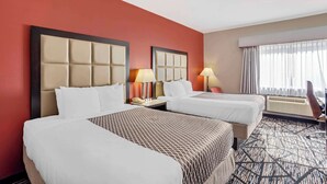 A hotel room with two beds, a large mirror, and a window with curtains. - Best Western Carlisle (Carlisle)