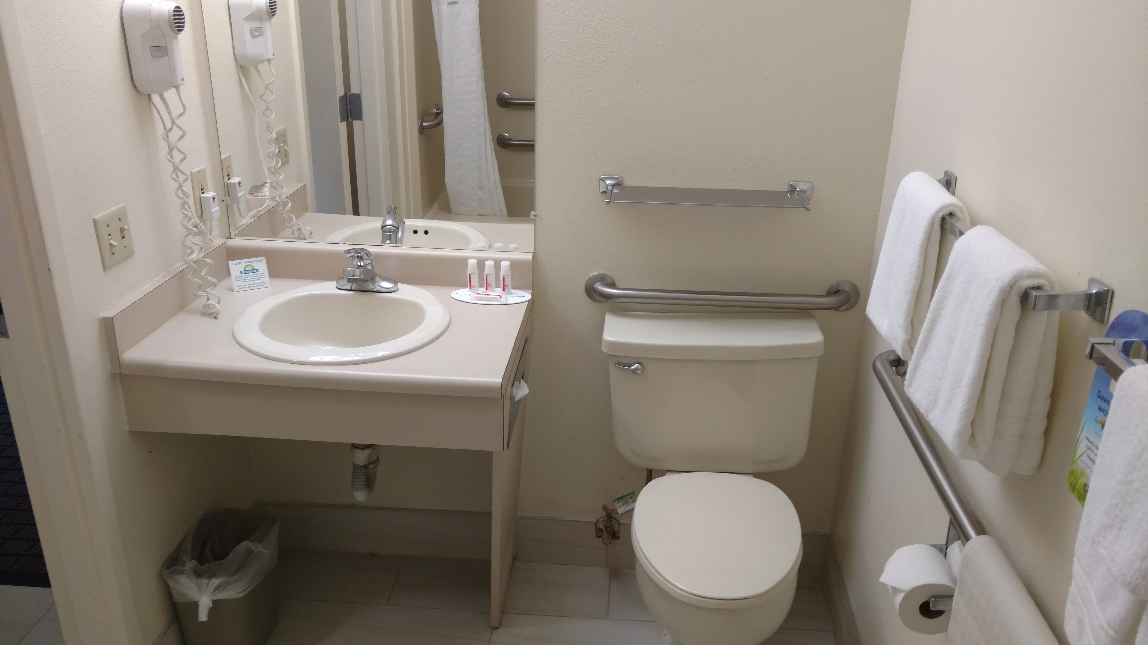Une petite salle de bain comprenant un lavabo, des toilettes et un sèche-mains.