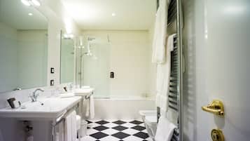 Un baño moderno con suelo a cuadros blanco y negro, un espejo grande, dos lavamanos, una bañera y un inodoro.