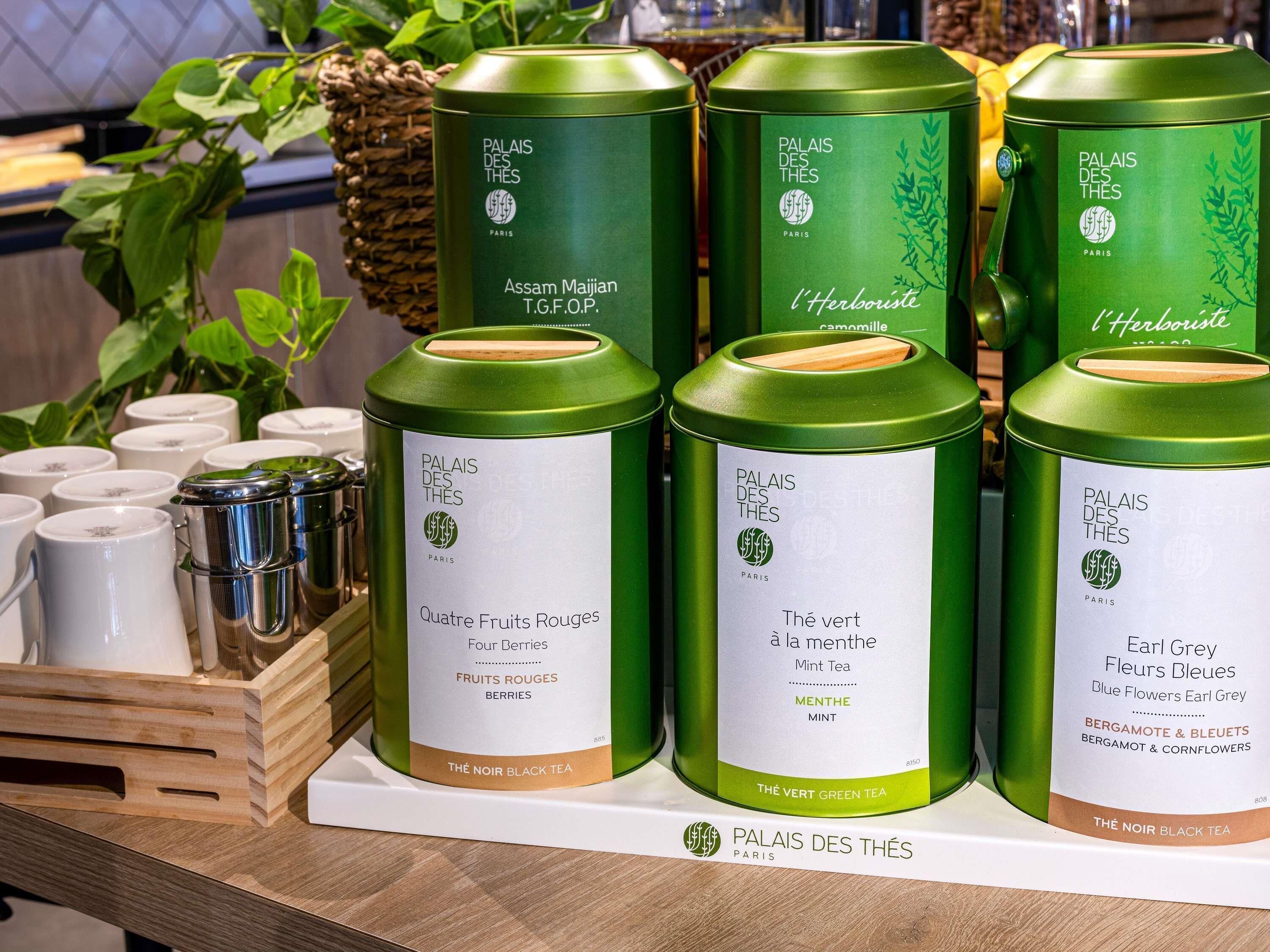 Exhibición de latas de té con etiquetas que indican distintos sabores y tipos.