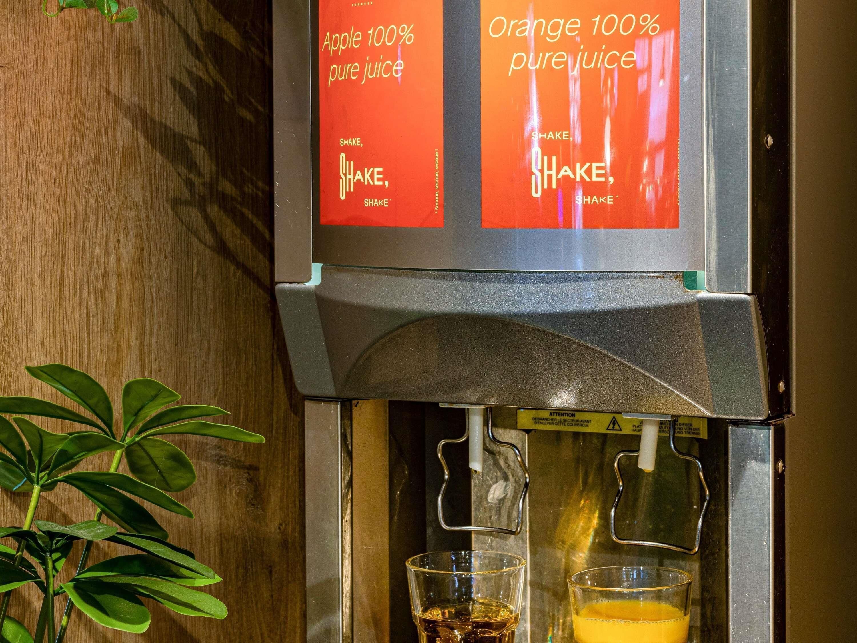 Dispensador de jugo con etiquetas para jugo de manzana y jugo de naranja 100% puro.