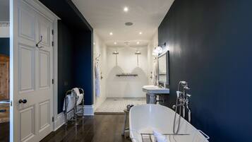A modern bathroom with a freestanding bathtub, a vanity with a mirror, and a shower area.