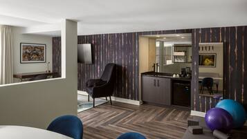 Une chambre d’hôtel moderne comprenant un coin repas, un espace de vie et une kitchenette.