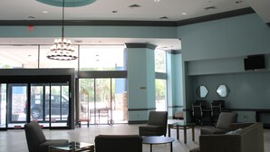 A lobby with a reception desk, seating area, and large windows. - Clarion Inn & Suites Florence - Darlington (Florence)