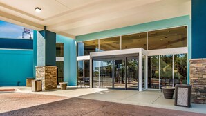 A modern building with a blue exterior, large glass doors, and a stone pillar. - Clarion Inn & Suites Florence - Darlington (Florence)