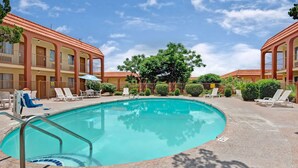 A pool area with lounge chairs and a building with a red roof. - Super 8 by Wyndham El Paso Airport (El Paso)
