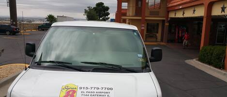 Una camioneta blanca estacionada frente a un edificio con un letrero que indica que es un motel Super 8.