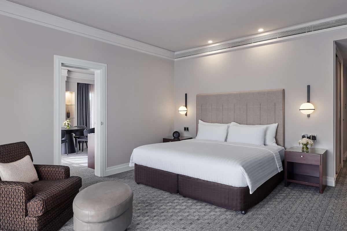 Een hotelkamer met een groot bed, een slaapbank, een nachtkastje en een stoel.