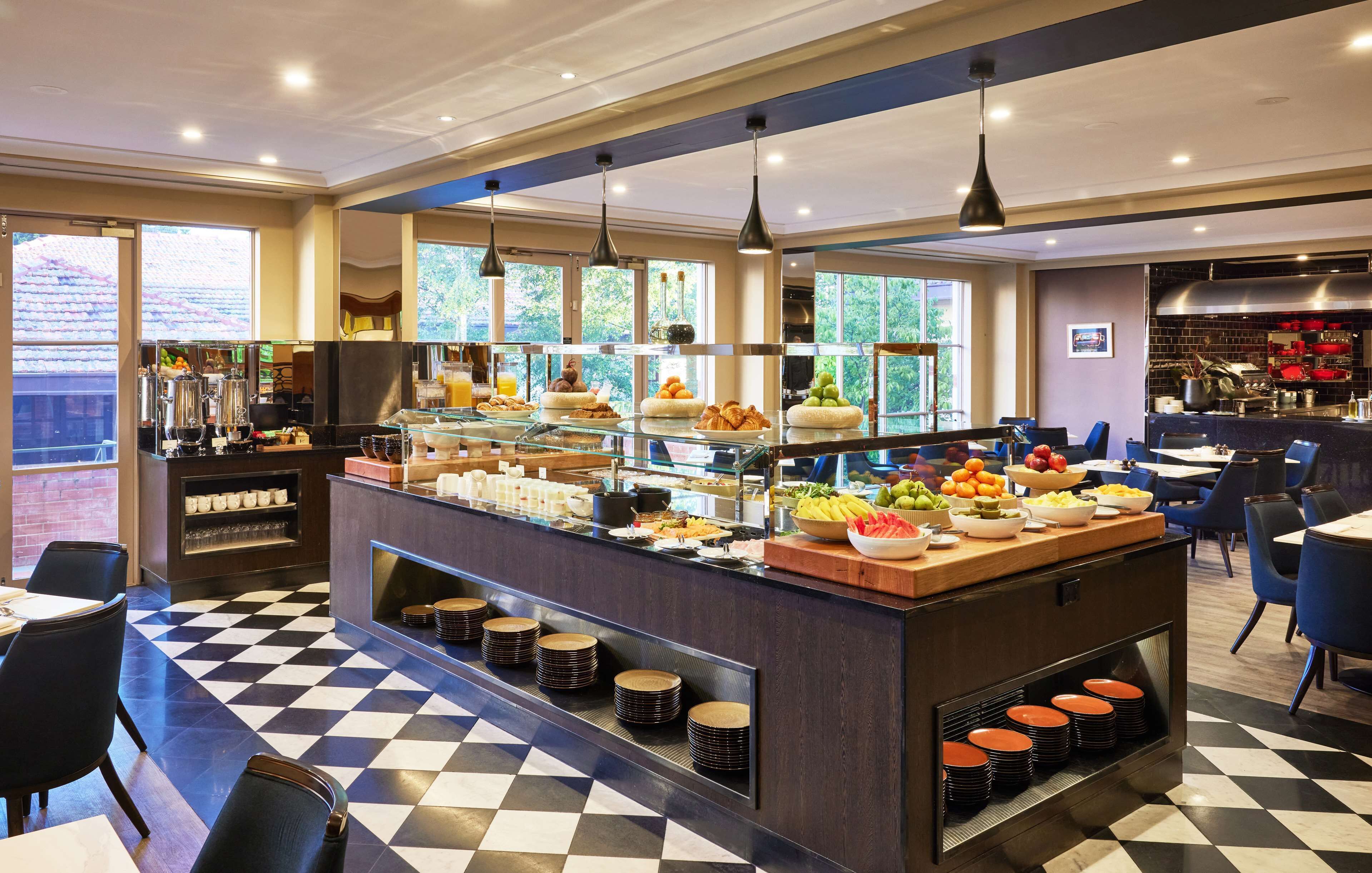 A buffet area with a variety of food items, a checkered floor, and a seating area with tables and chairs.