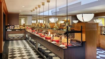 A buffet setup with a checkered floor, multiple serving stations, and hanging pendant lights.