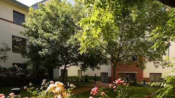 Stroll through the serene courtyard surrounded by mature trees and beautifully maintained gardens.