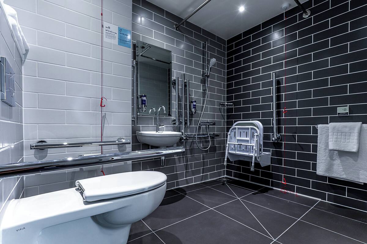 A modern bathroom with a toilet, sink, and shower.