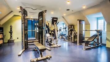 Uma academia com diversos equipamentos de exercício, incluindo esteiras, aparelhos de musculação e pesos livres.