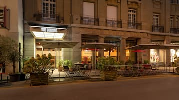 A building with multiple balconies and a cafe named "The Bristol" with outdoor seating.