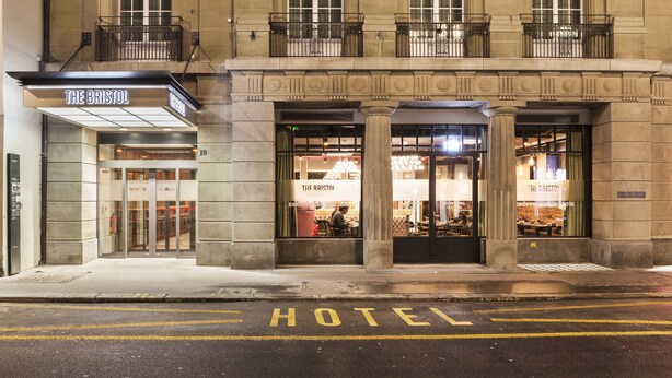 A hotel entrance with a sign reading "The Bristol Hotel." - NH Bern The Bristol (Bern)