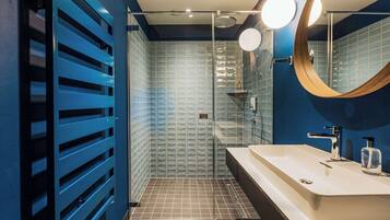 A modern bathroom with a shower, a sink, and a mirror.