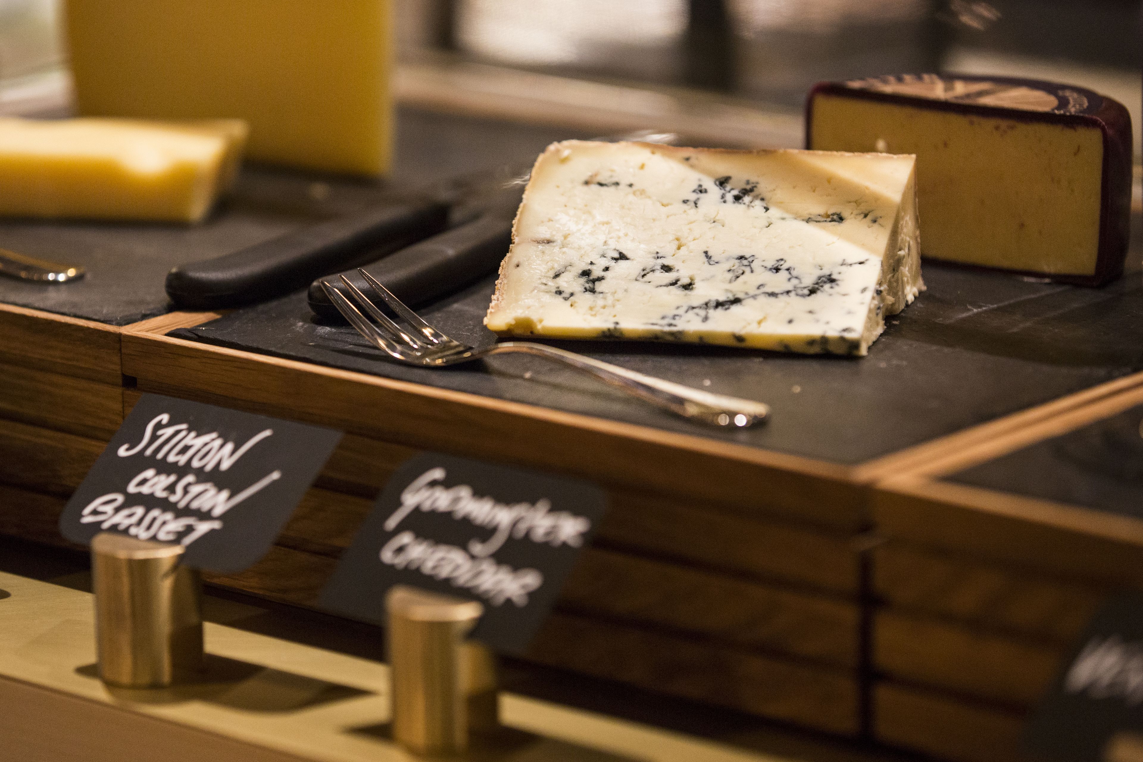 A cheese display with labels for 'Stevion Colston Basset' and 'Goumiere Cheese'.