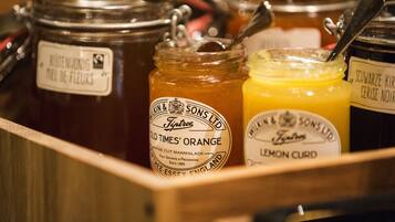 Une vitrine en bois contenant plusieurs pots de miel et de confiture d’agrumes.
