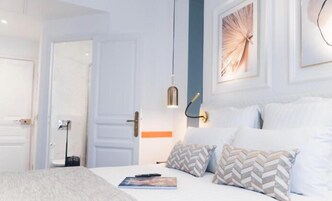 Un dormitorio moderno con una cama, una mesita de noche, una lámpara y una puerta.