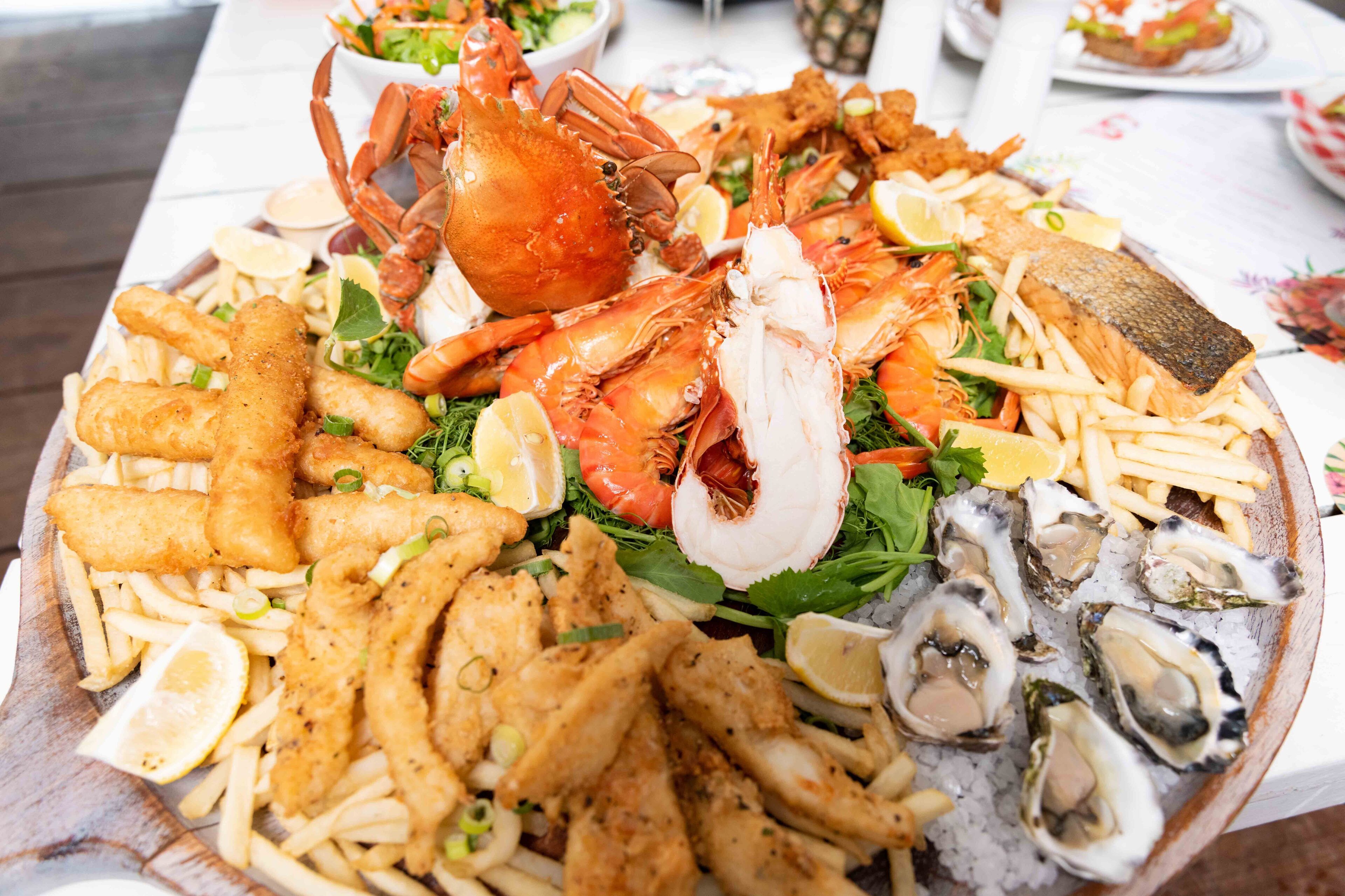 A seafood platter with various items including fish, shrimp, and oysters.
