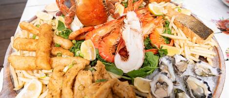 A seafood platter with various items including fish, shrimp, and oysters.