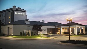 A Courtyard by Marriott hotel with a modern design, a covered entrance, and well-lit surroundings.