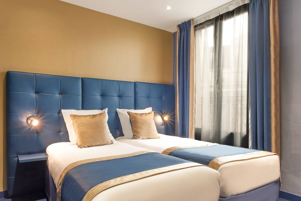 A hotel room with a large bed, two bedside tables, and a nightstand.