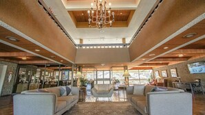 A spacious lobby with a chandelier, sofas, and a patterned rug. - Palm Springs Tennis Club (Palm Springs)