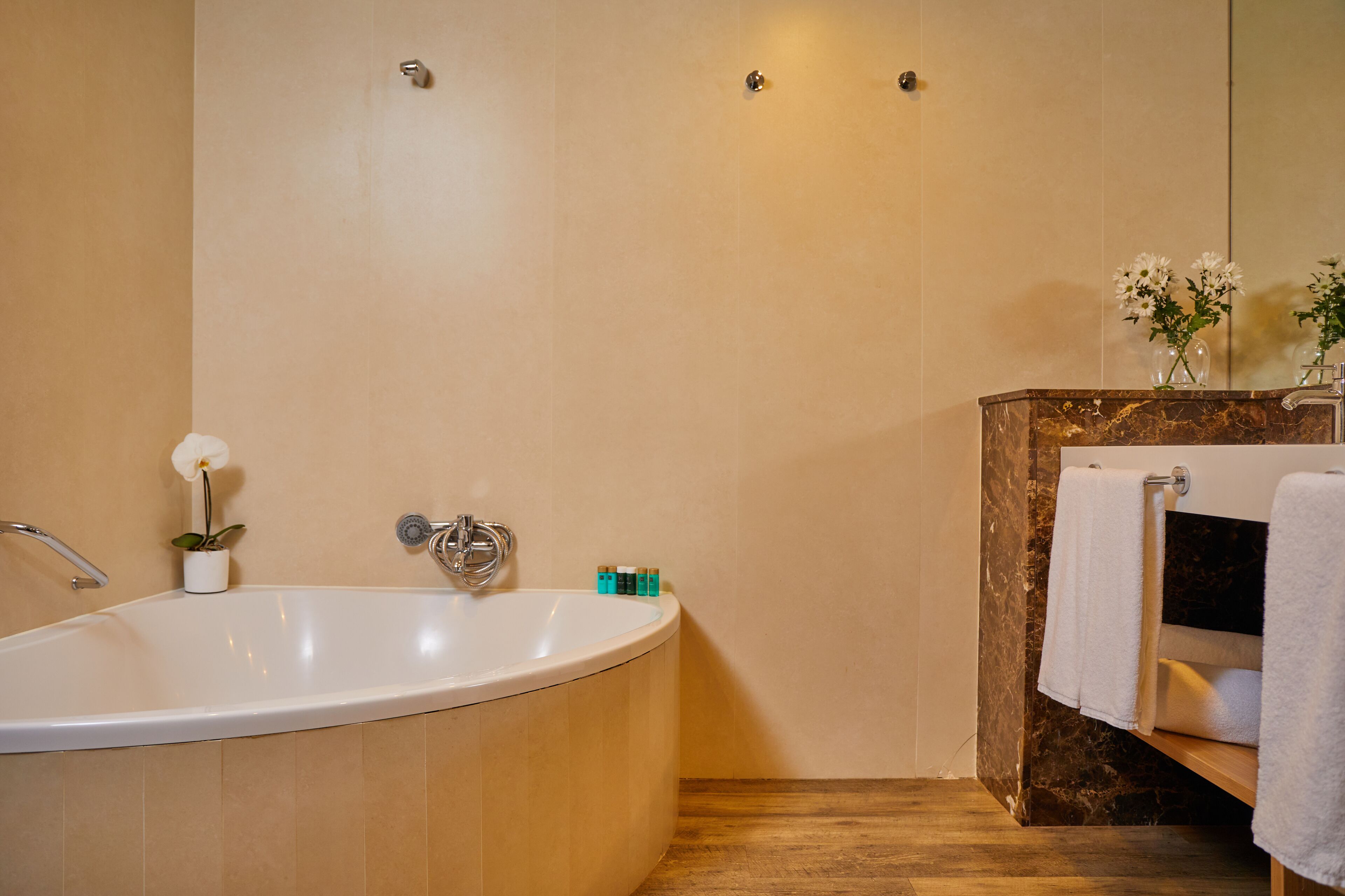 A modern bathroom with a freestanding bathtub, a marble vanity, and a large mirror.