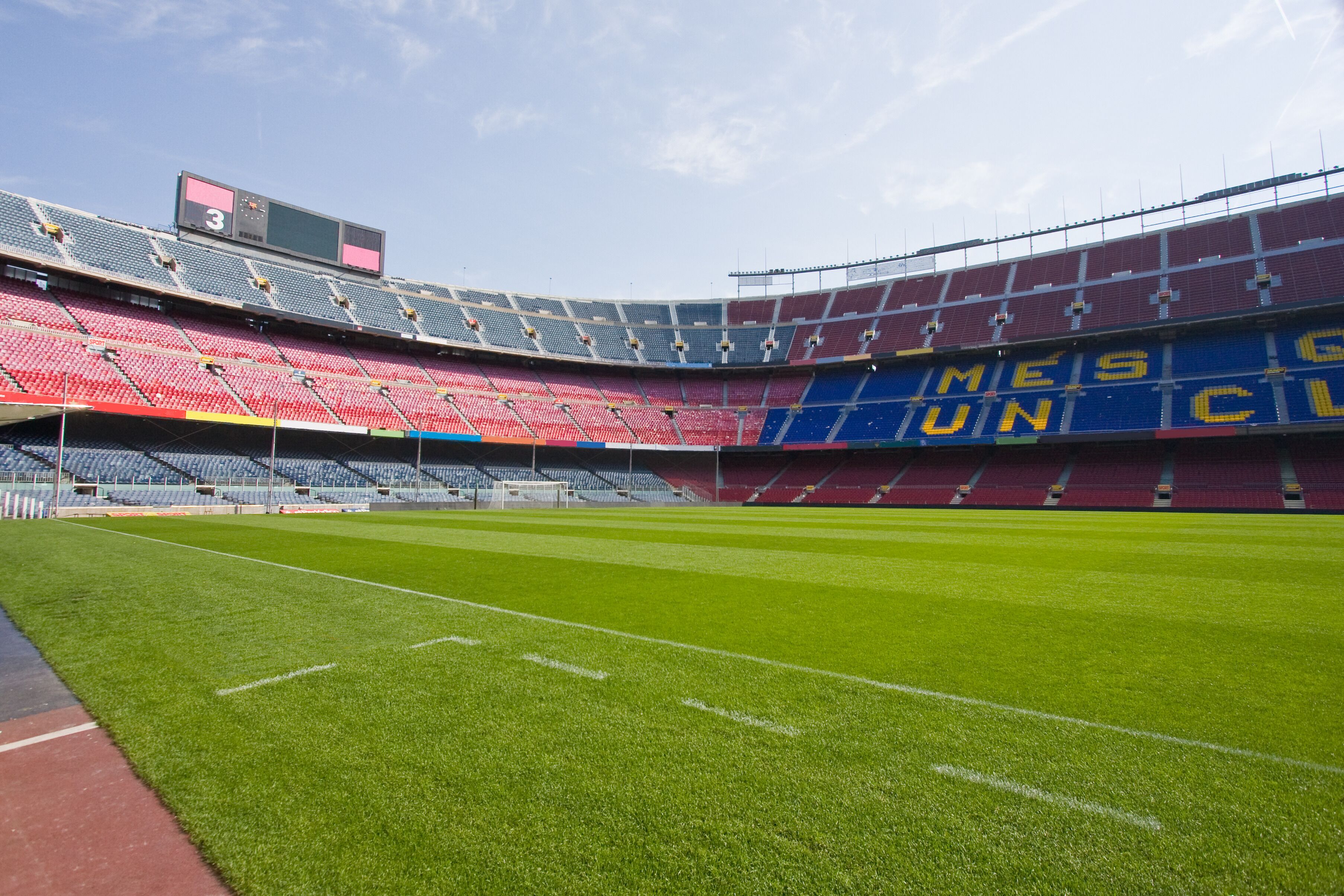 A stadium with tiered seating and a large digital scoreboard.