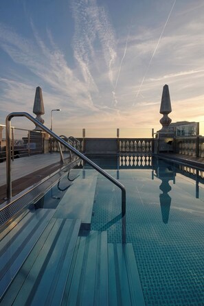 Una piscina al aire libre, tumbonas