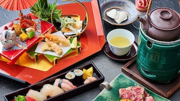 A variety of Japanese dishes including sushi, tempura, and sashimi, served on traditional tableware.