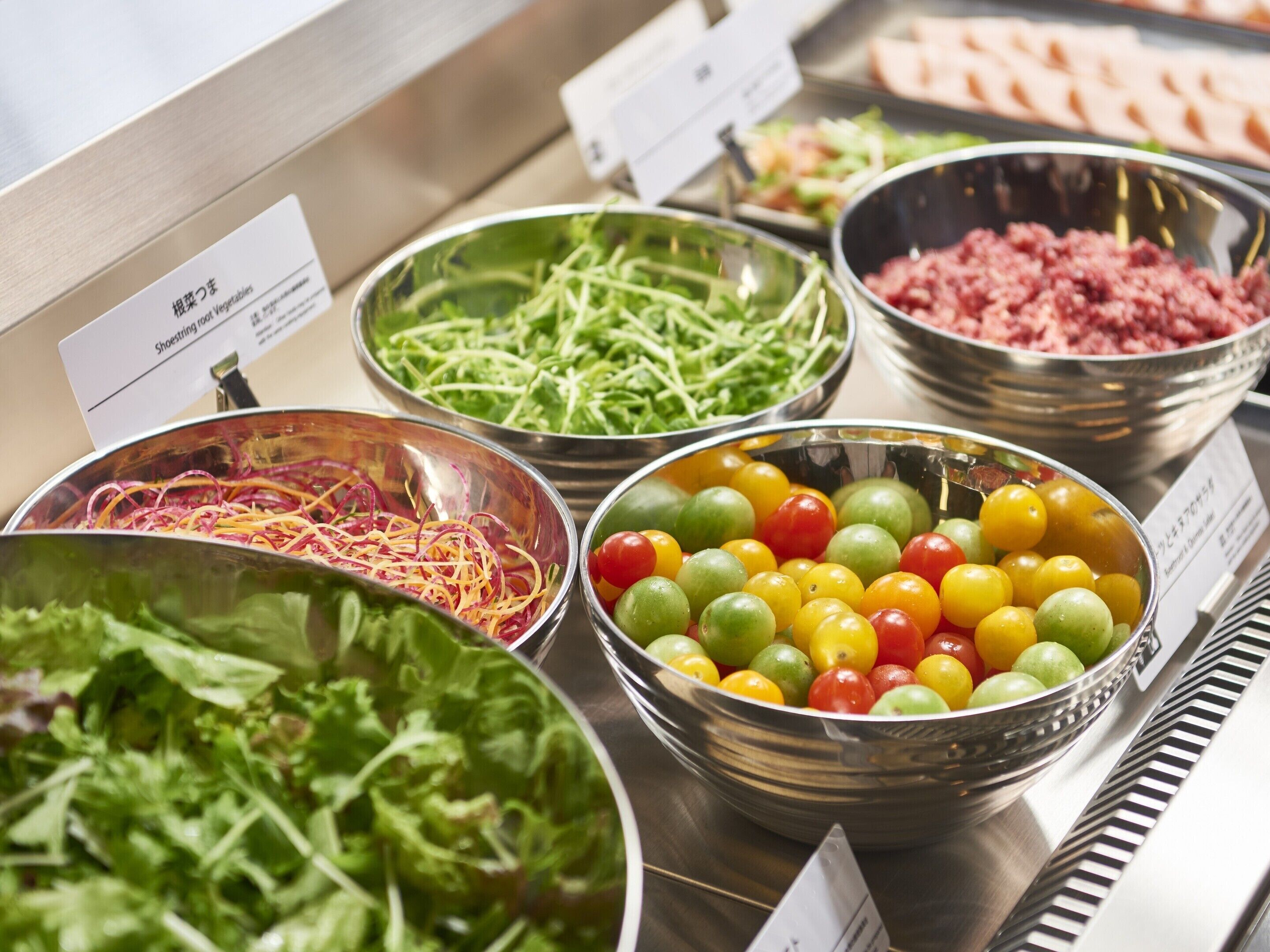 A buffet with various food options including salads, vegetables, and meats.