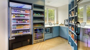 A modern kitchen with a built-in refrigerator, microwave, and a vending machine. - City Express By Marriott King of Prussia (King of Prussia)